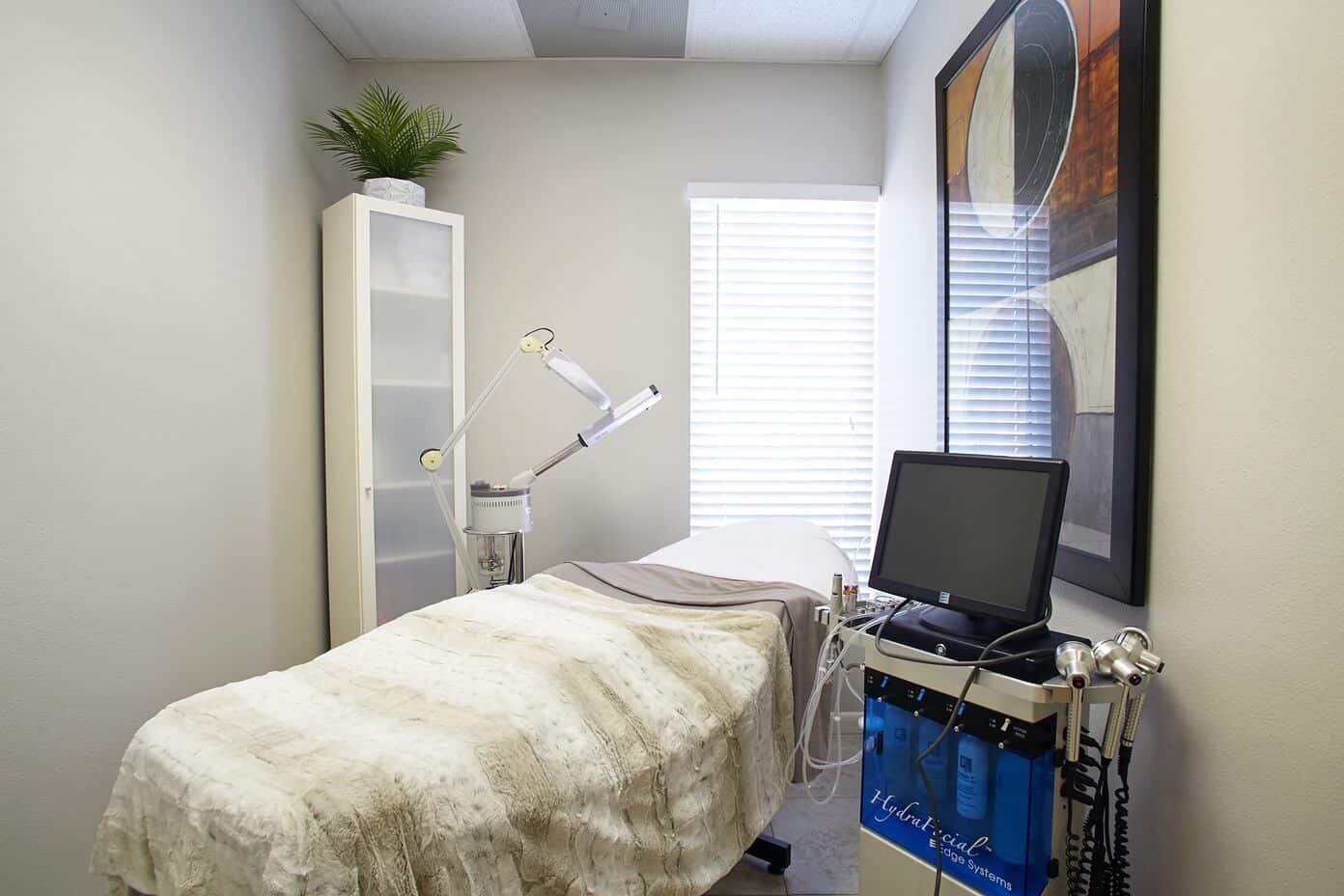 Facial room with treatment bed and HydraFacial system